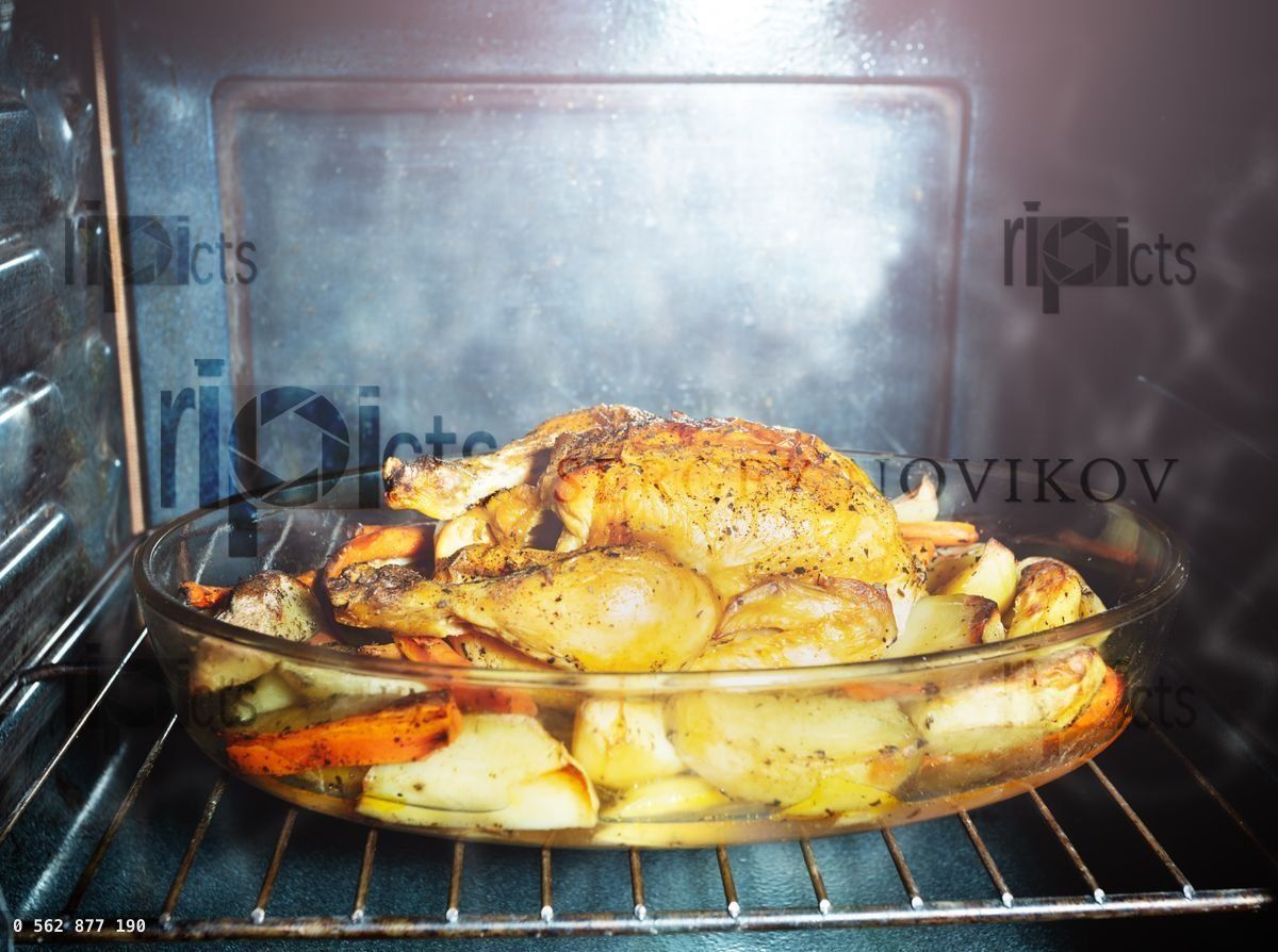 Fried chicken dish with potato view inside oven