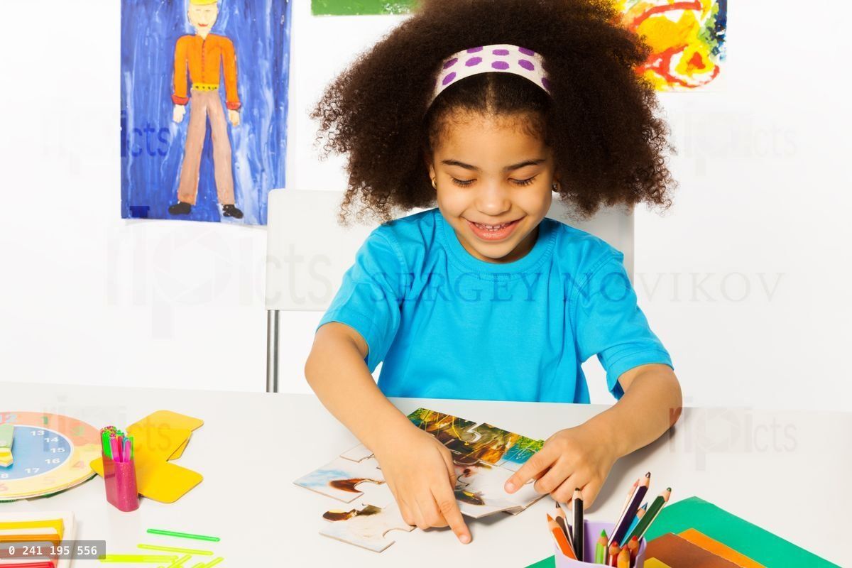 Petite fille africaine assemblant des pièces de puzzle