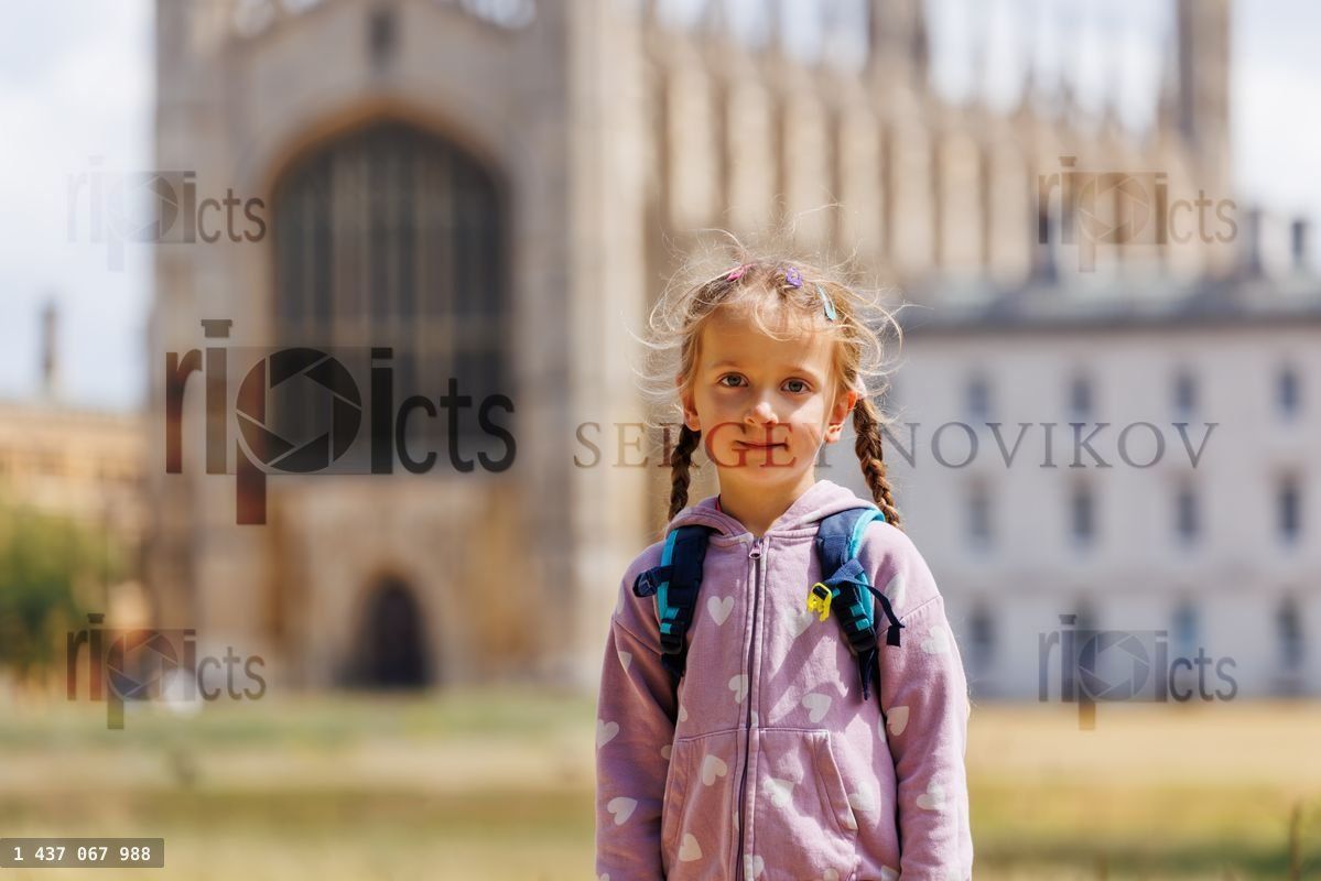 Young girl with backpack standing at historic Cambridge campus