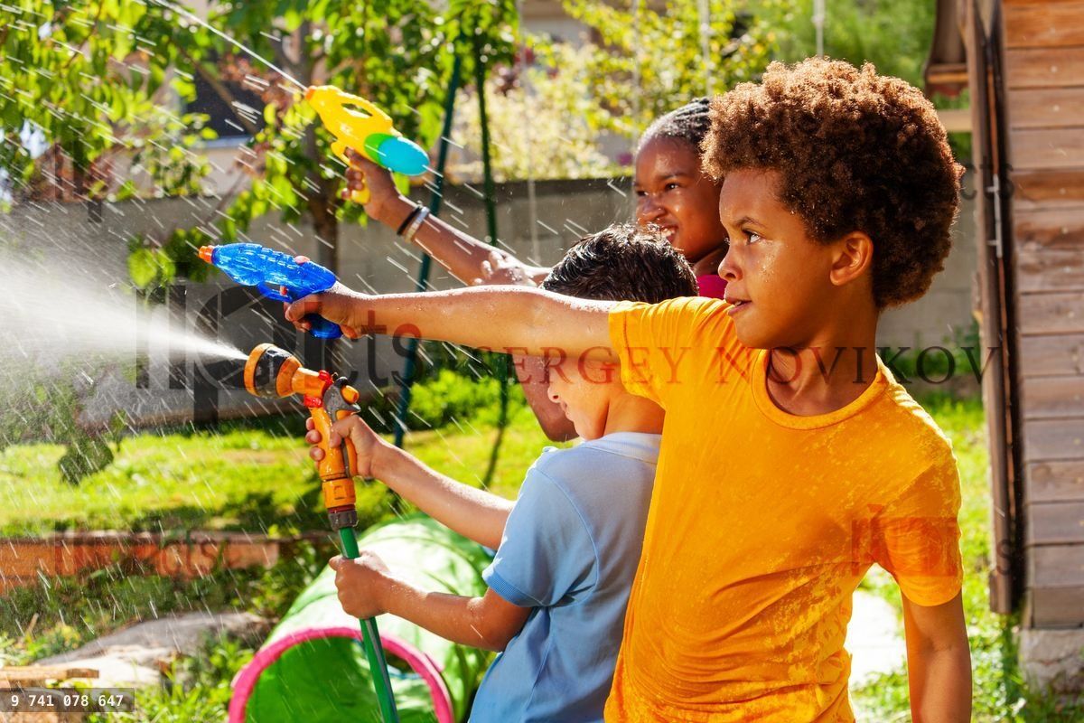 Boy with group of children shoot water pistol