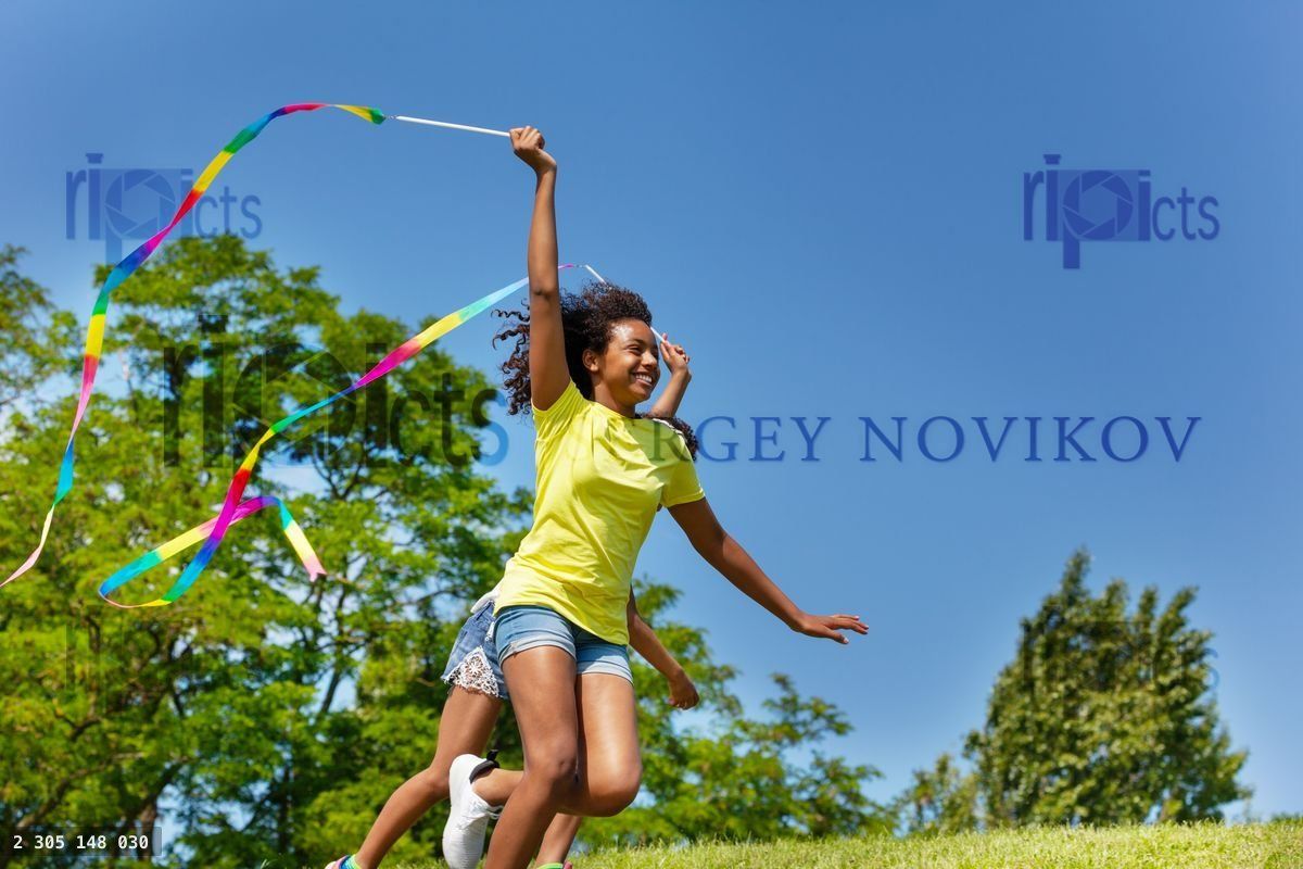 Young black girl run with ribbon over blue sky