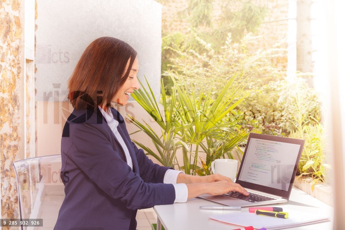 Woman in business suit working with laptop at cafe