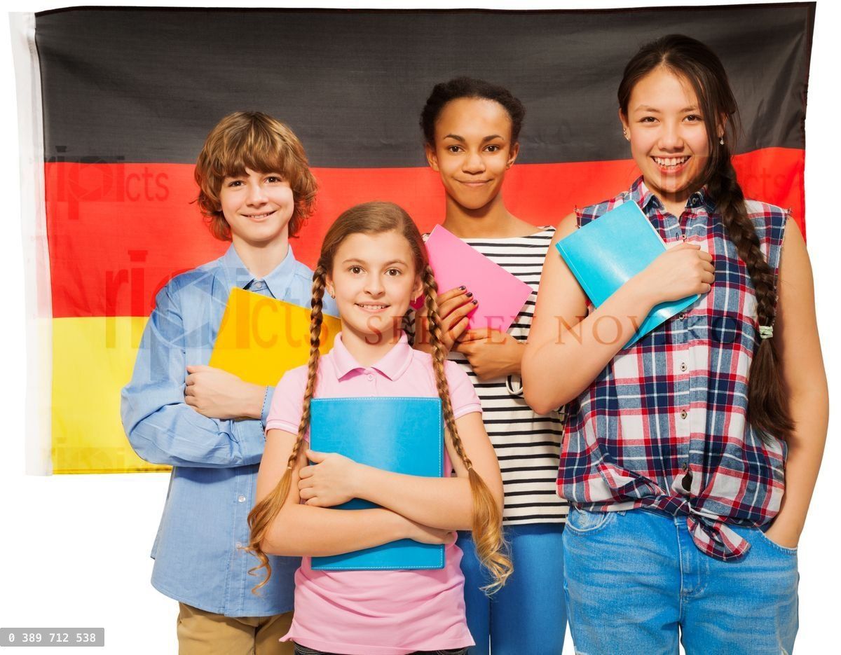 Four happy students standing against German flag
