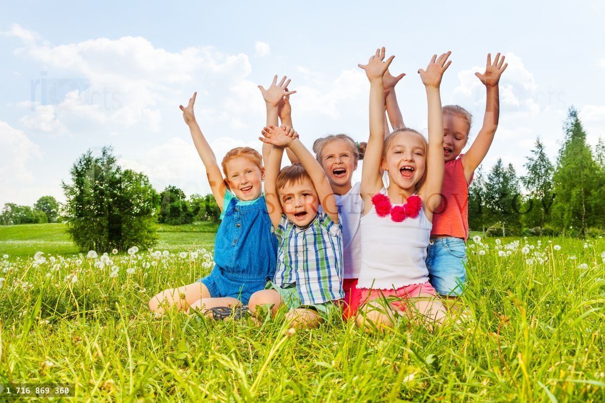 Funny children sitting on a meadow