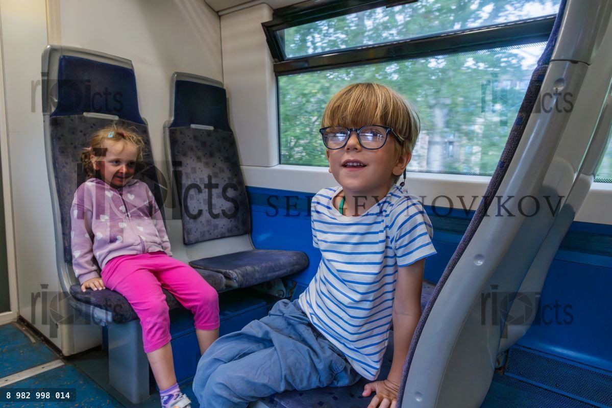 Youngsters enjoy a train trip, sitting happily on the car seats
