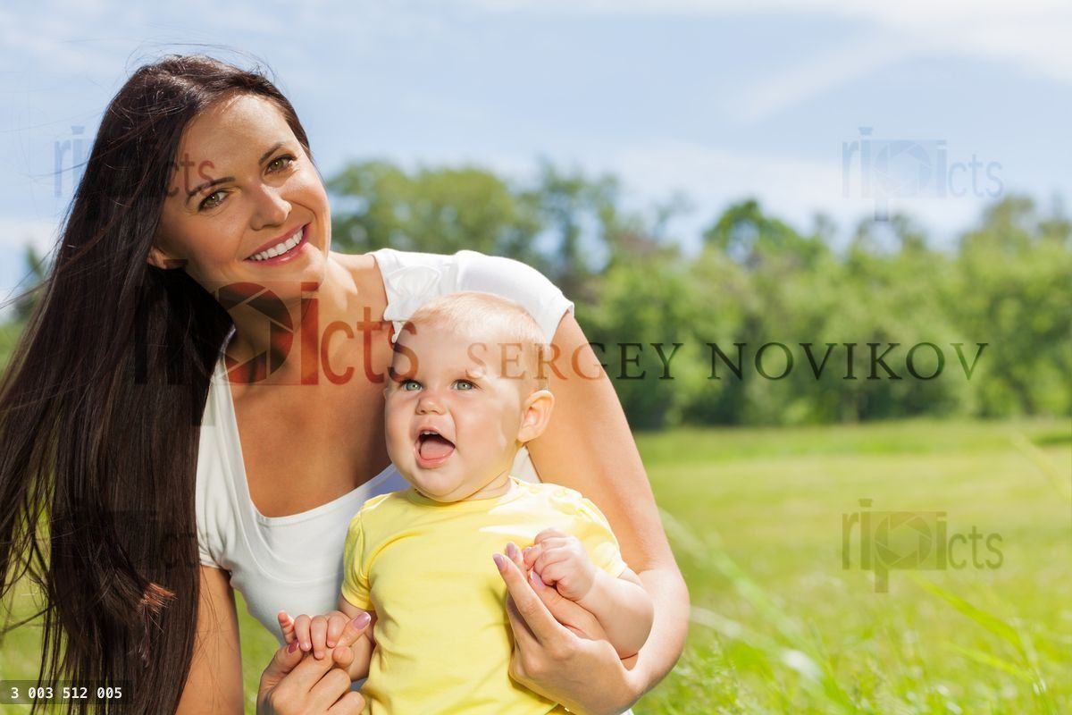 Mère heureuse avec son enfant dans la prairie verte