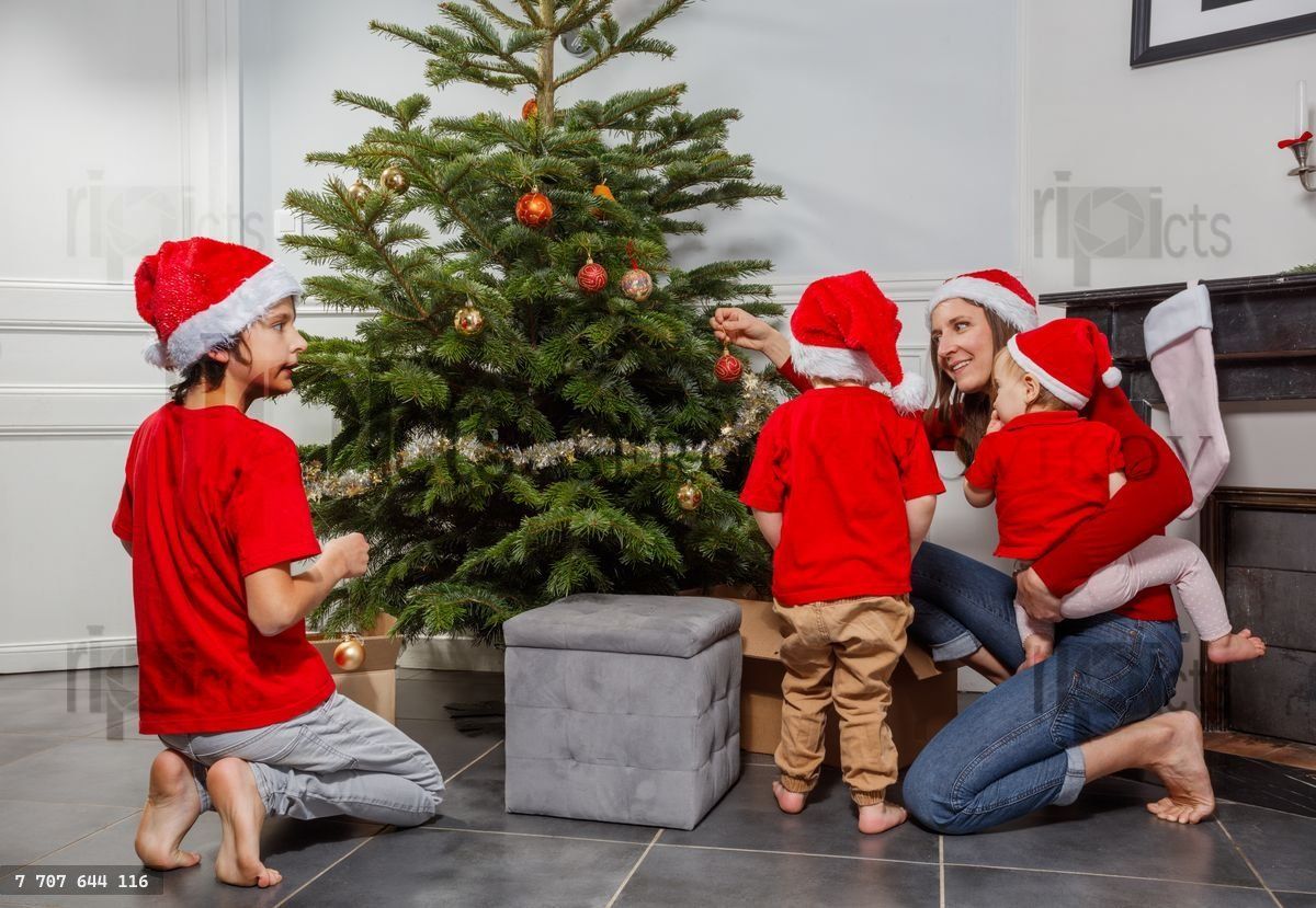 La joie de Noël alors que la famille décore ensemble le sapin avec des boules dorées