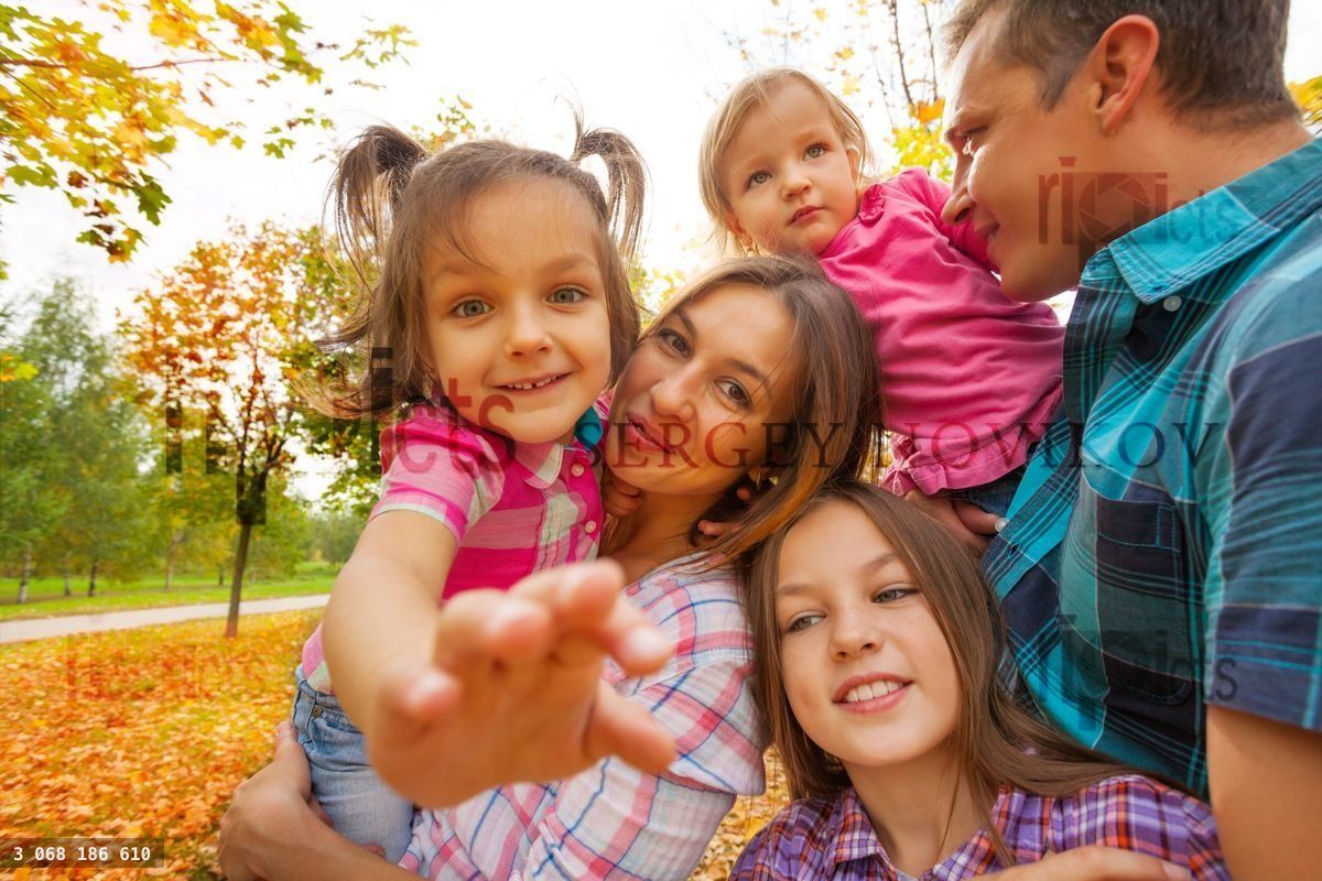 Family with little kids sit, play in autumn park
