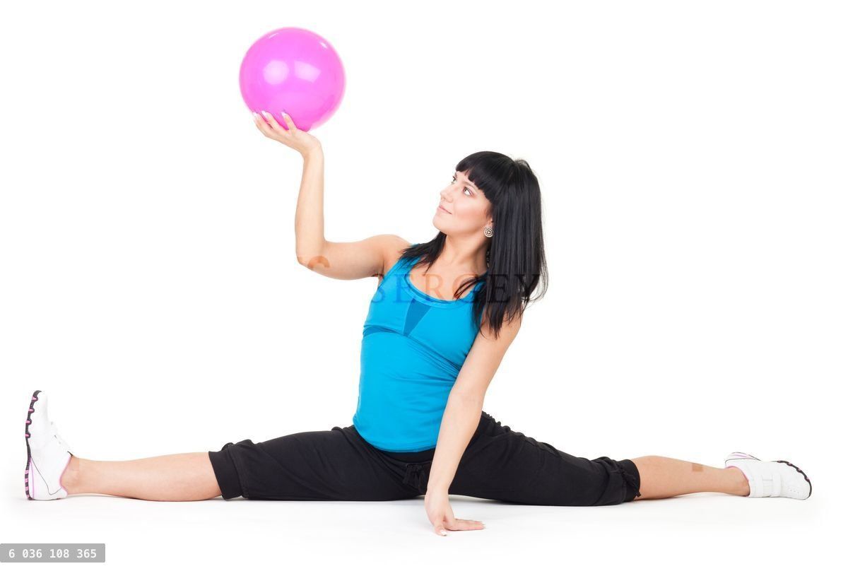Woman exercise with ball doing splits