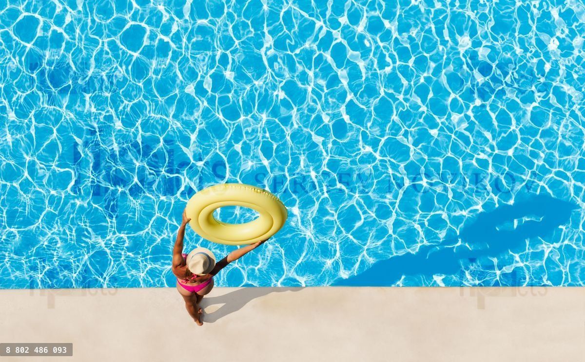 Woman holding rubber ring overhead at poolside