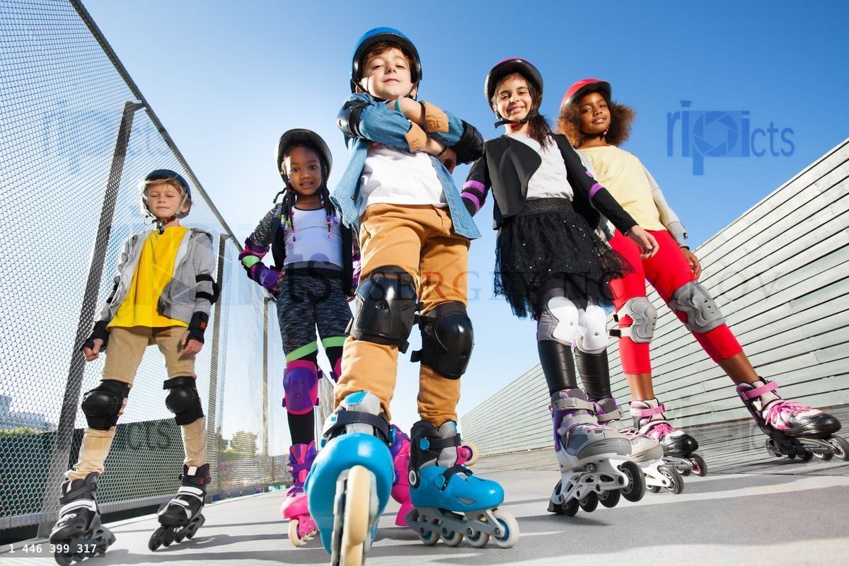 Boy in rollerblades standing with friends outdoors