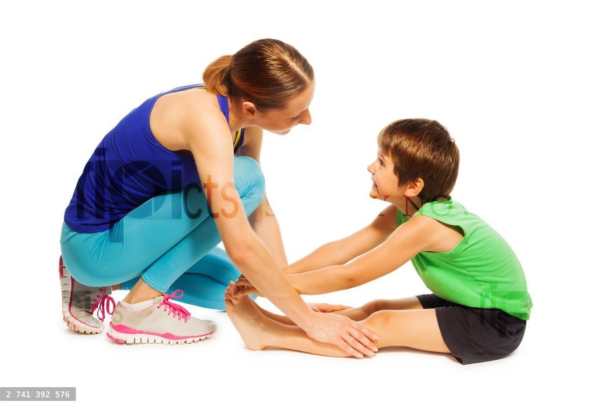 Young mother teaching son stretching leg muscles
