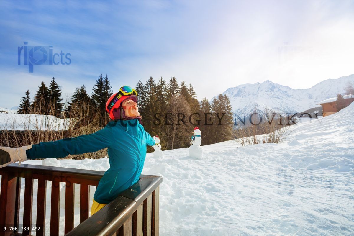 Woman stand on the balcony stretching hands relaxed ski outfit