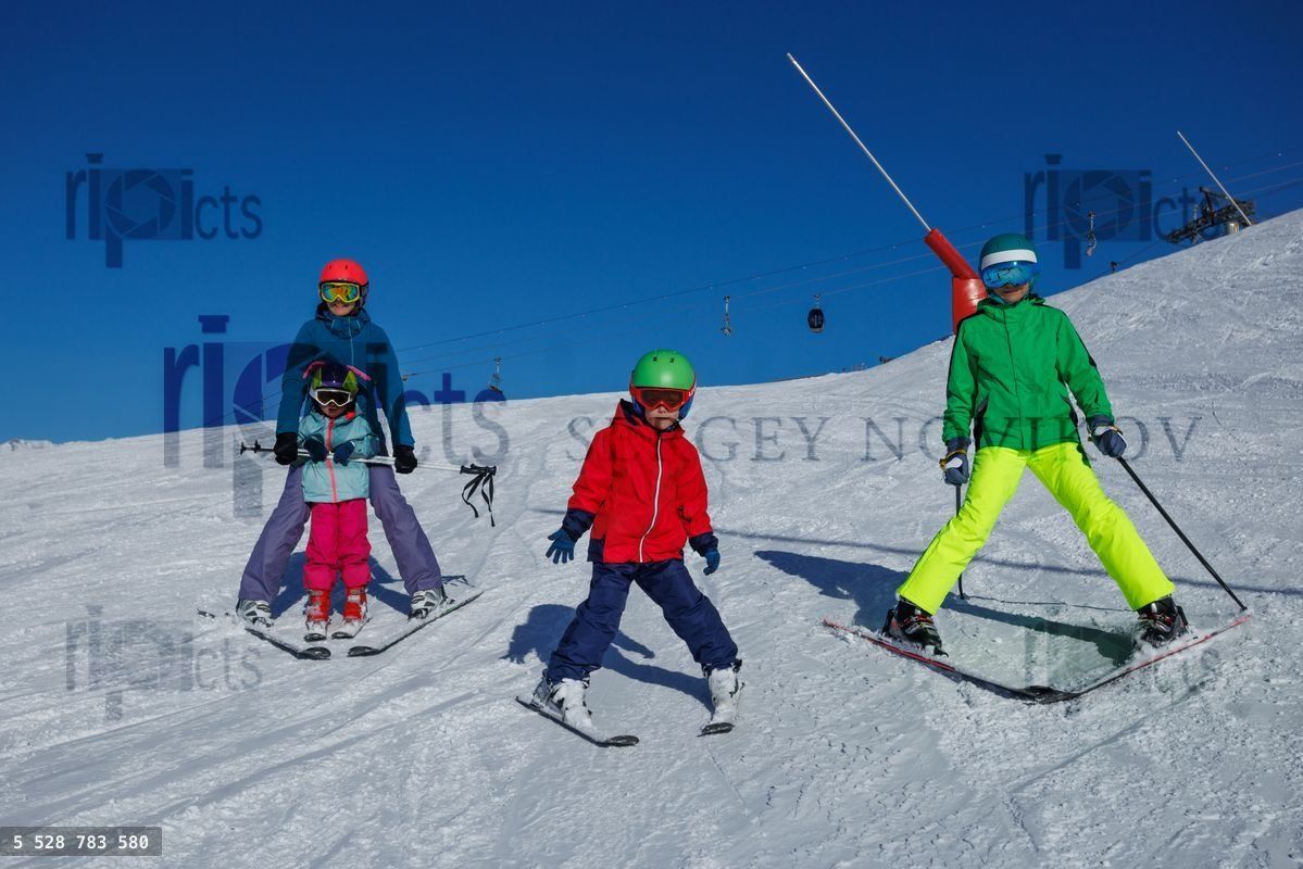 Young skier in red jacket glides down slope under vivid blue sky