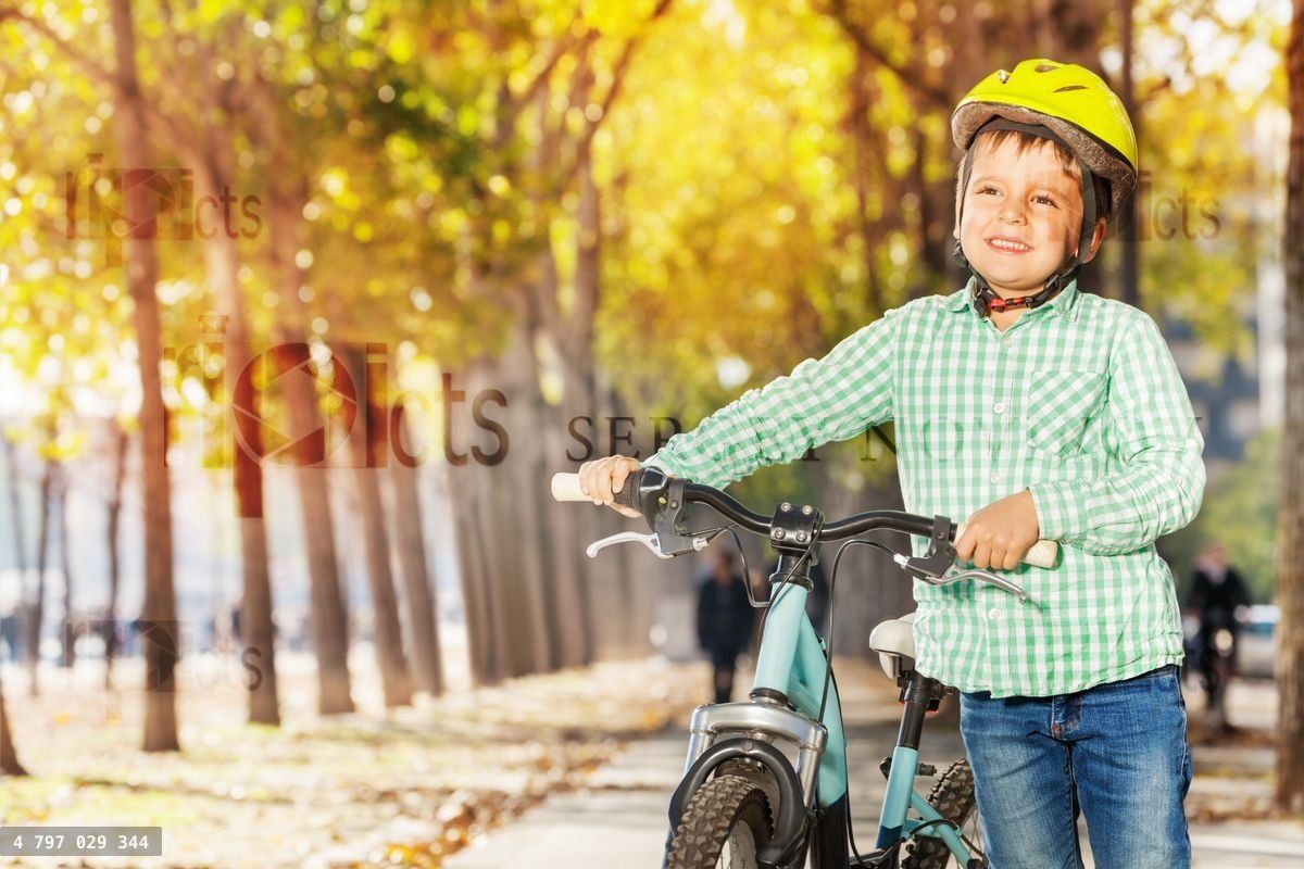 Close up portrait of boy with bike at autumn park