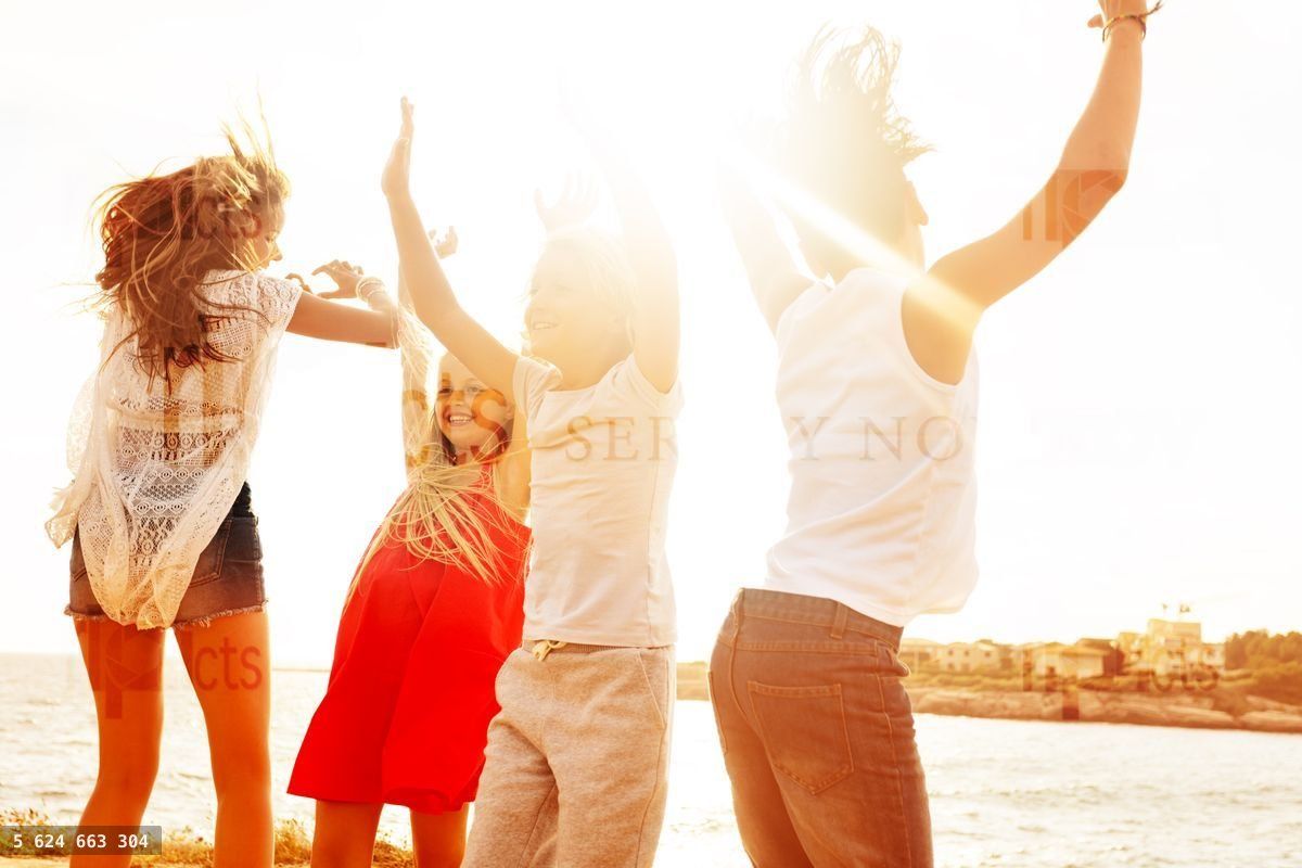 Friends dancing and having fun on the beach