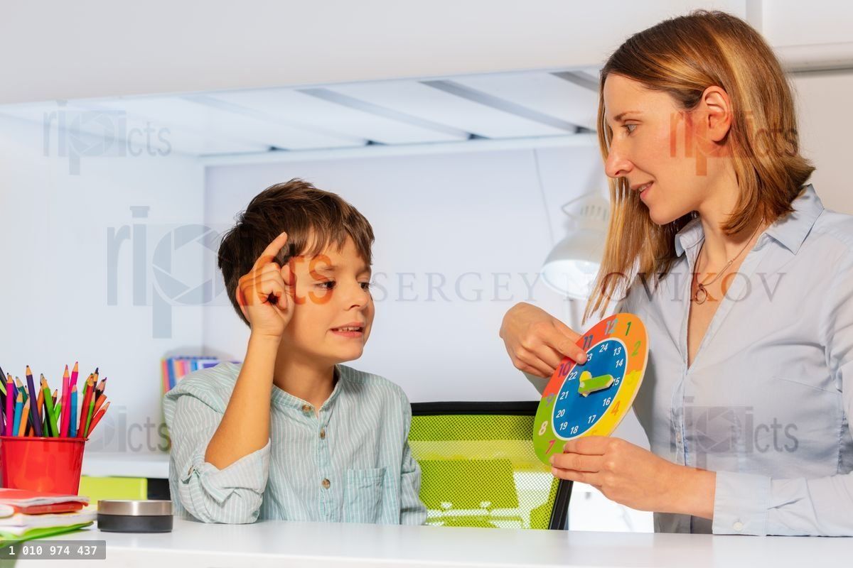 Woman teach boy with autism clock and hours