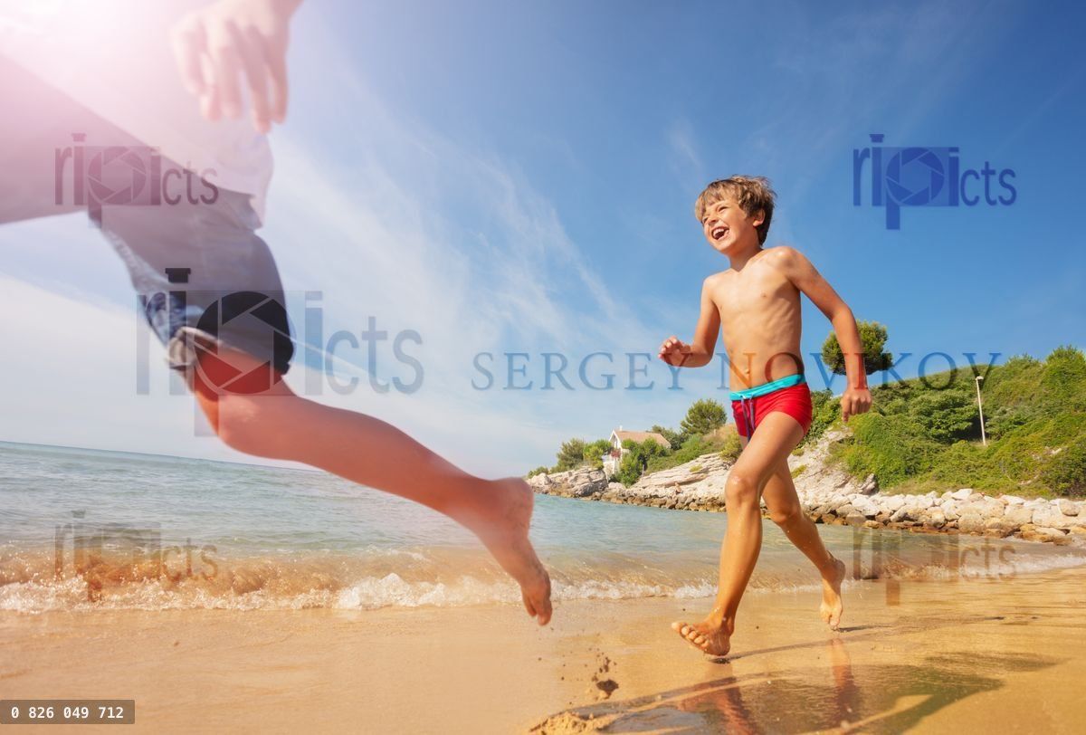 Happy boy playing beach games with friends