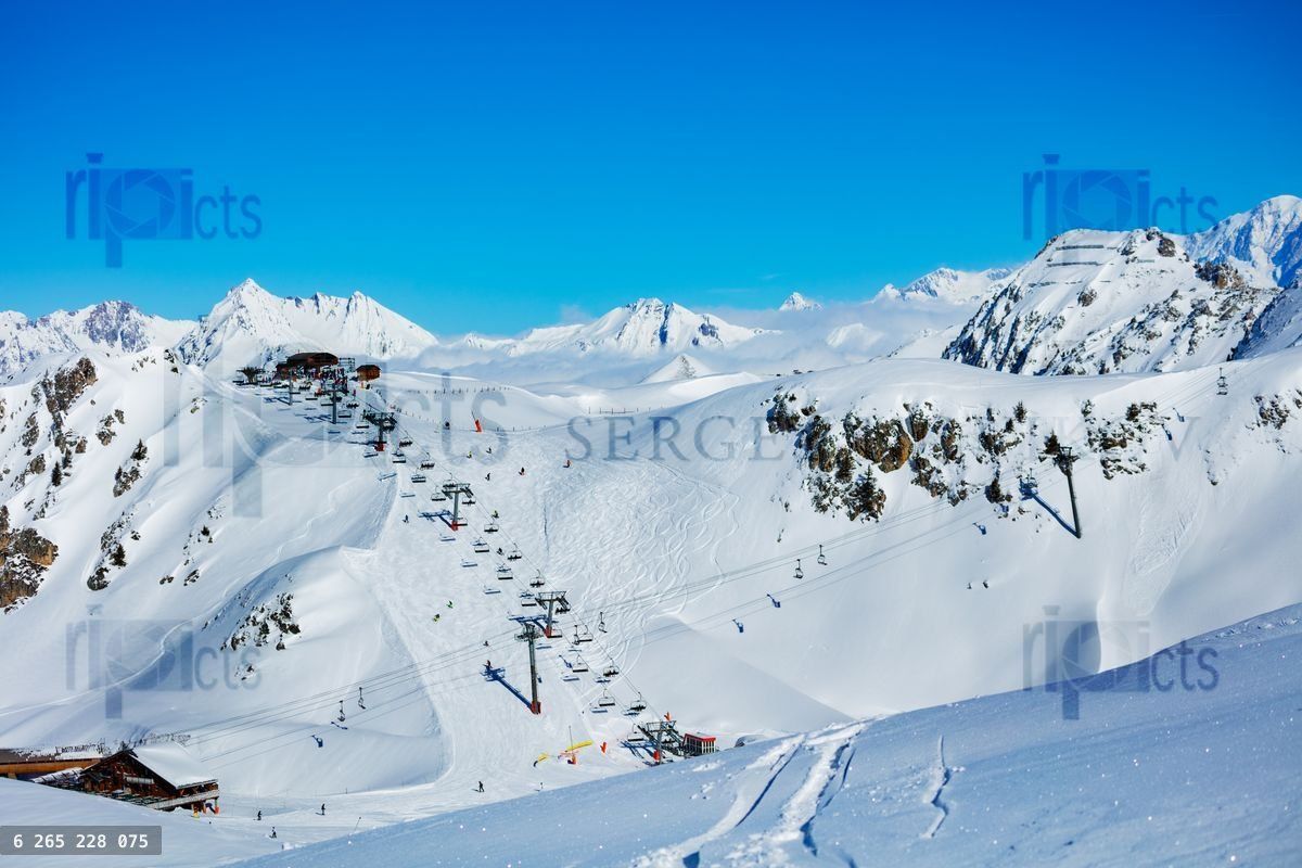 French alps and ski lift over snow mountain peaks