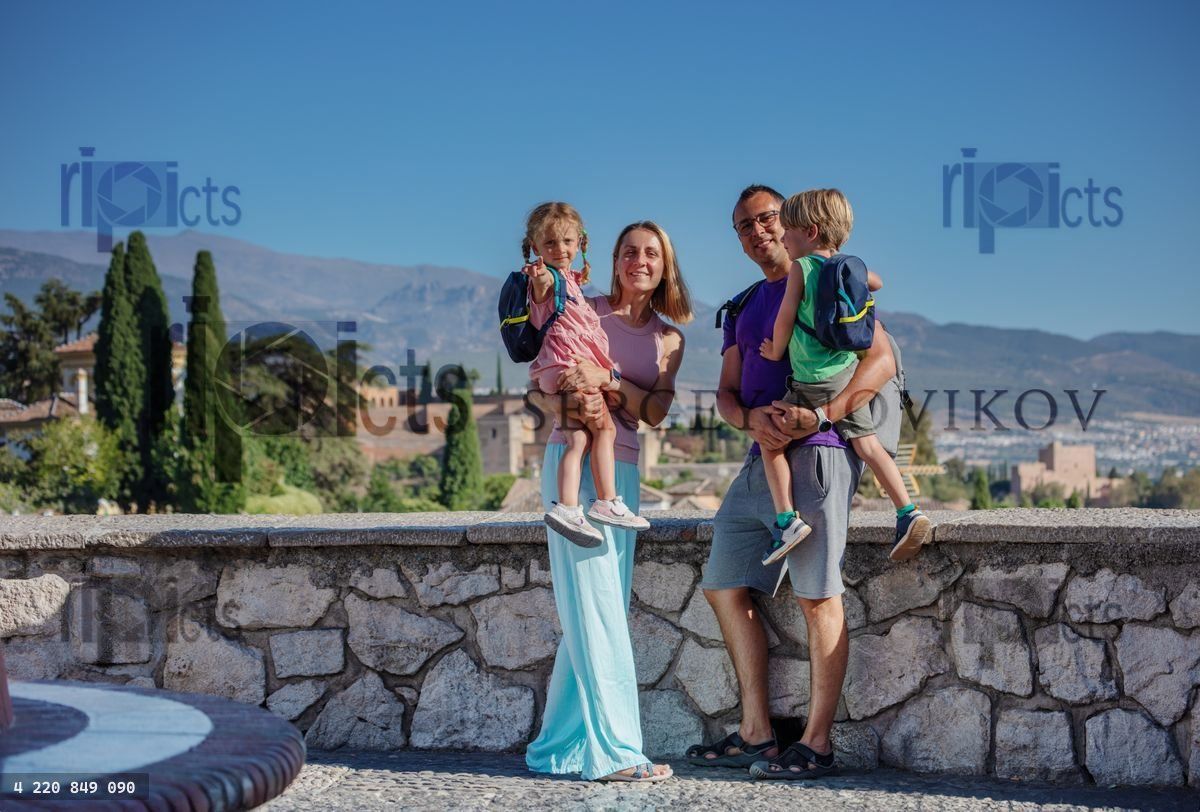 Young tourists with kids standing on viewpoint of Alhambra
