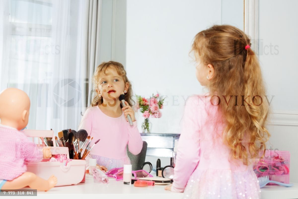 Girl and doll have playtime fun with makeup accessories of mom
