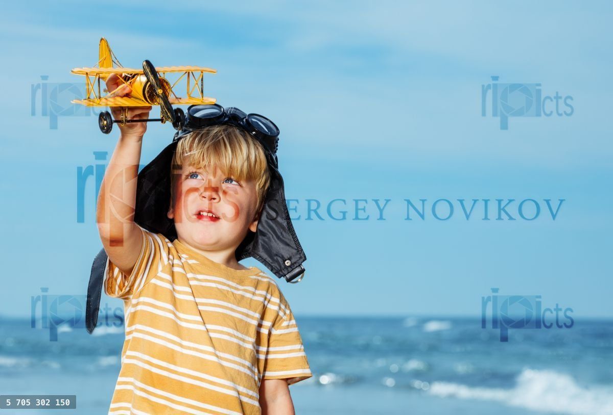 Close portrait of a little boy standing with toy model plane