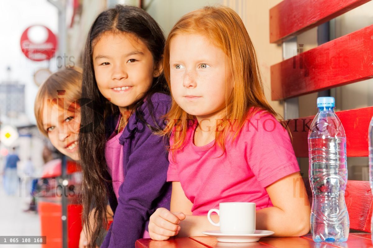 Groupe d'enfants internationaux assis dans un café en plein air