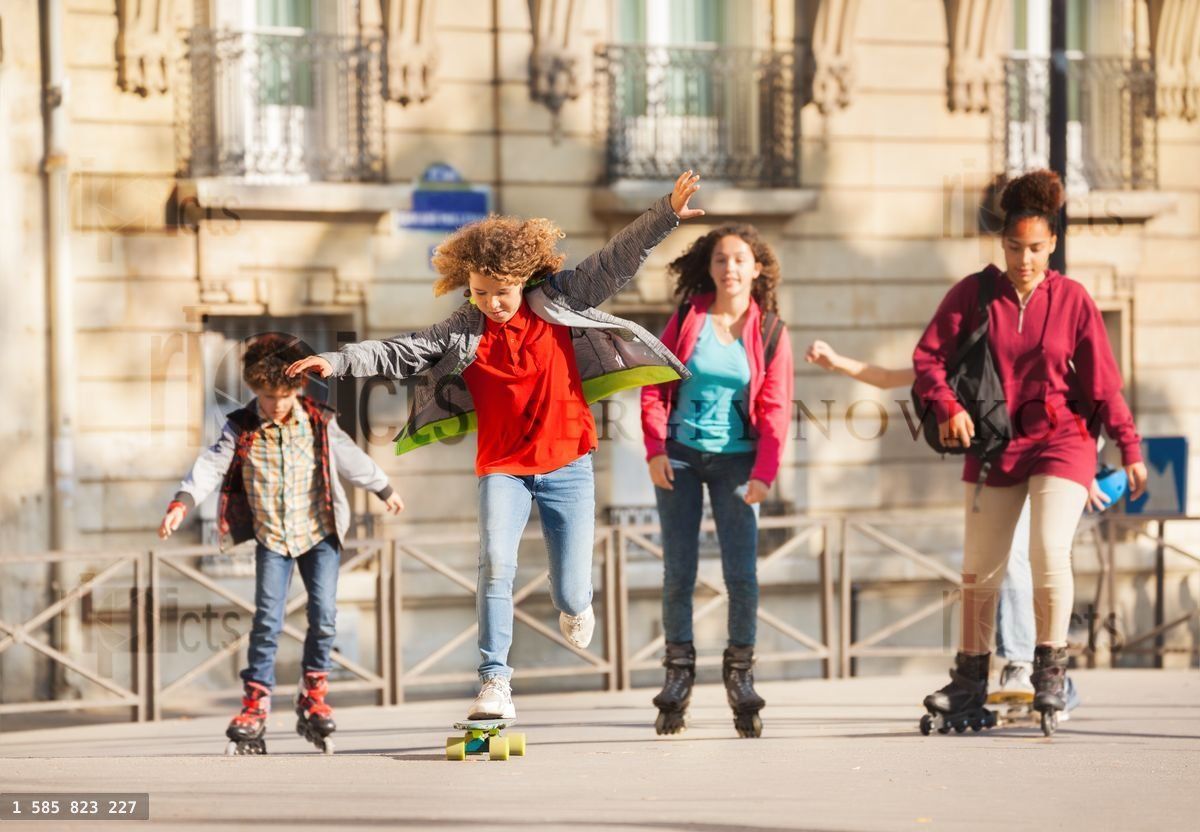 Friends skateboarding and rollerblading in city