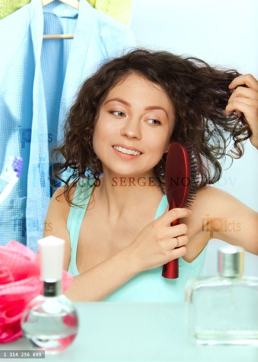 woman brushing hair in bathroom