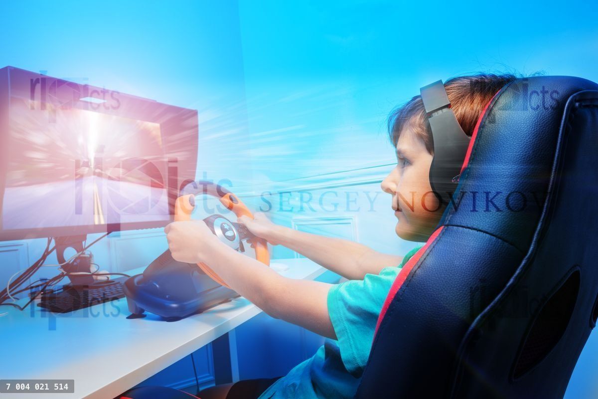 Boy with hands on steering wheel in headphones playing race game