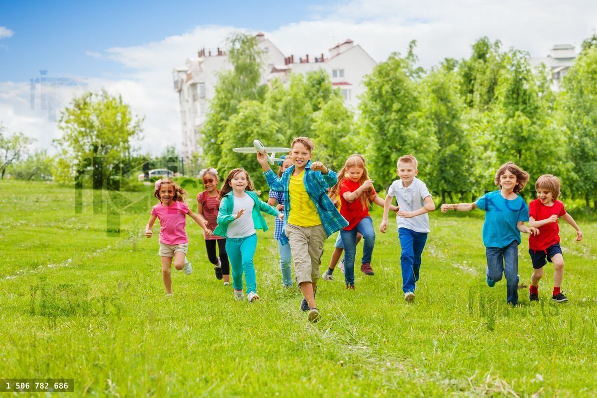 Boy holds big white airplane toy and kids behind