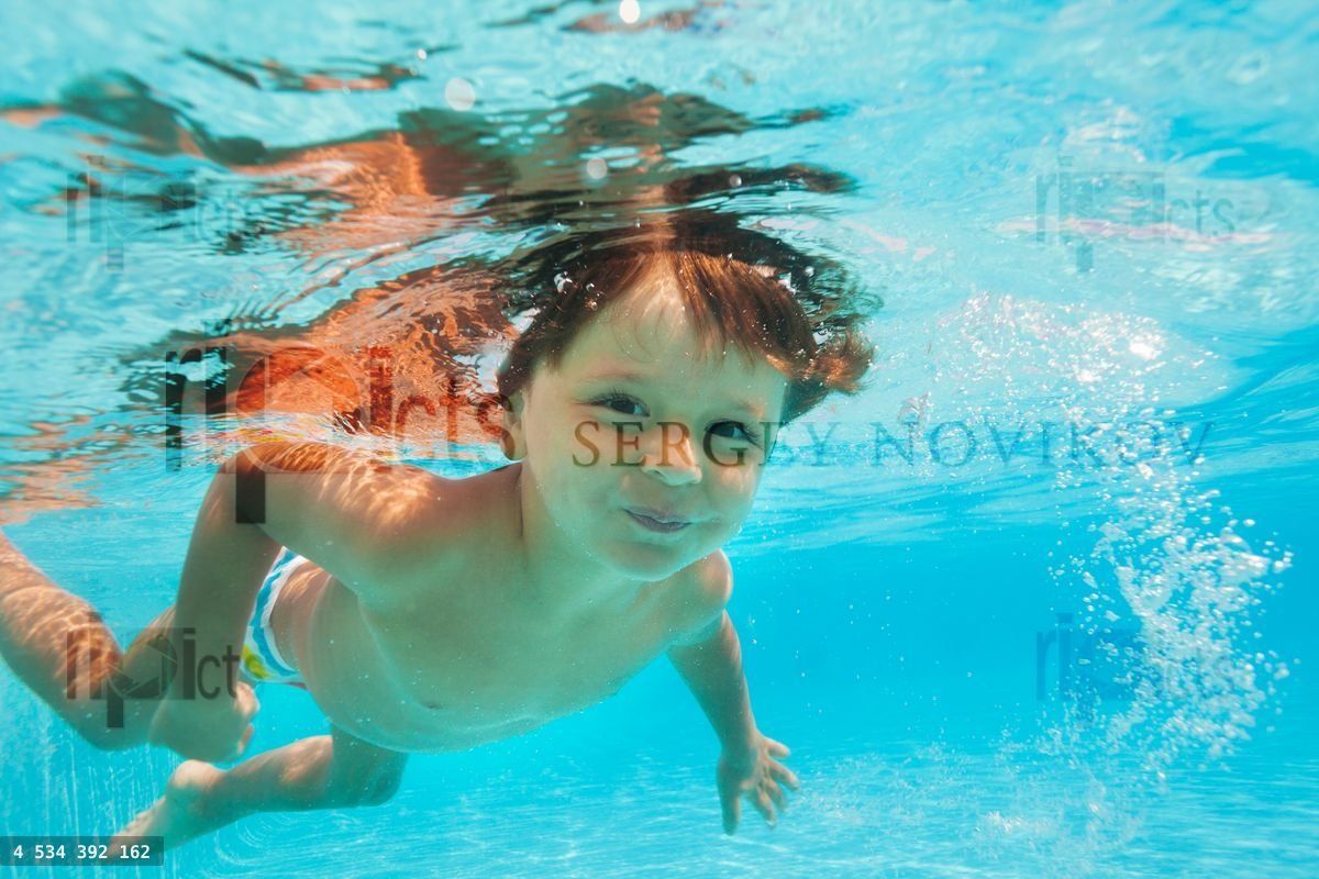 Close up view of small boy swimming under water