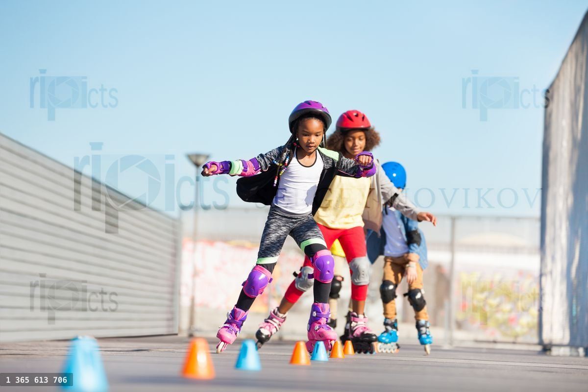 Young inline skaters doing tricks at skate park