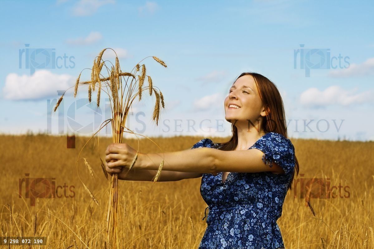 woman holding bundle of wheat ears