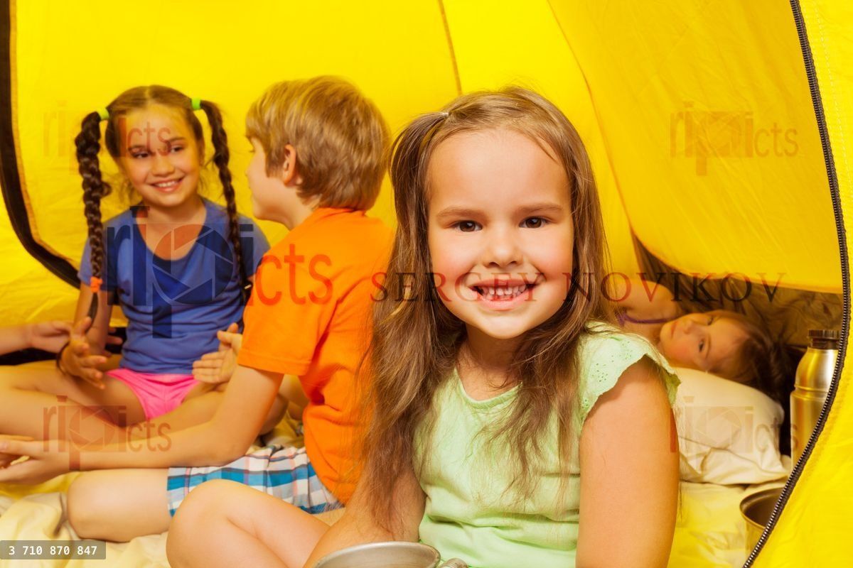Four pretty little kids sit in a tent