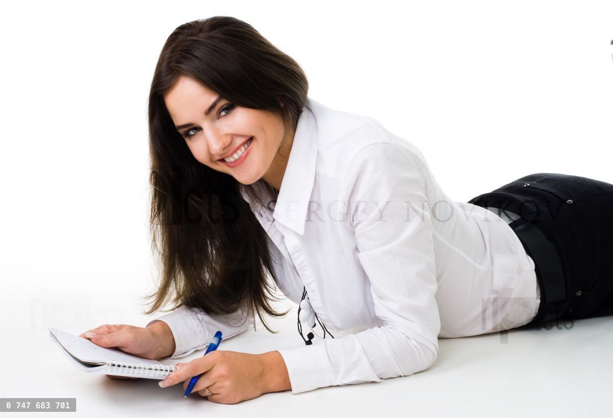 woman writ in notepad laying on the floor
