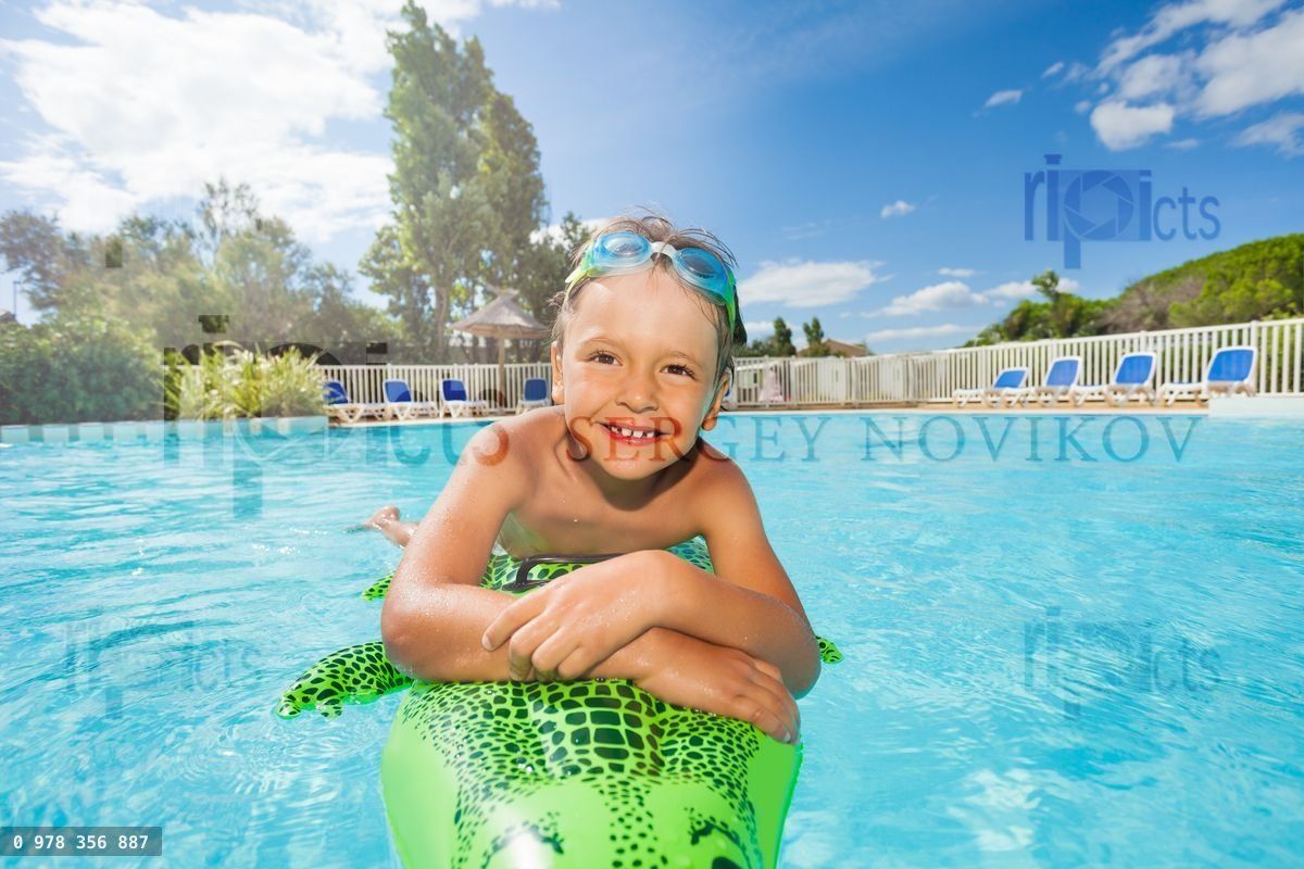 Happy boy relaxing on inflatable toy in pool