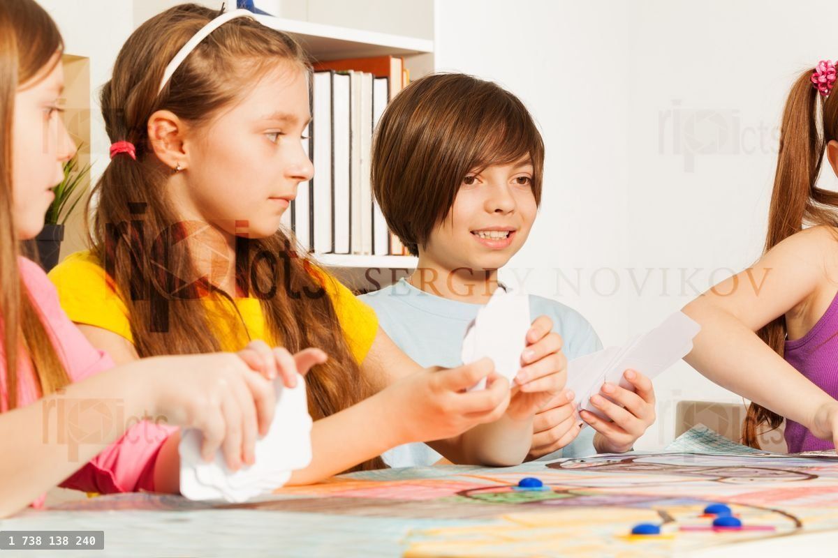 Four kids playing cards for a pastime