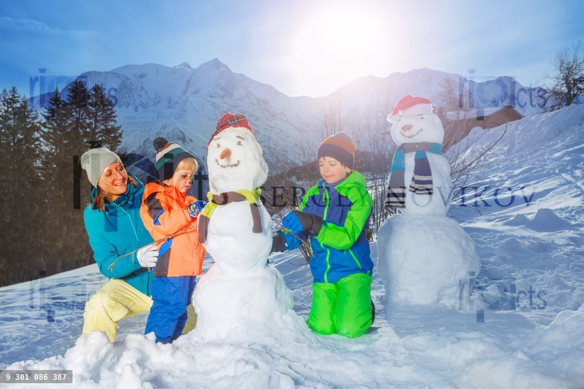Family build snowman dress with scarf, hat outside in mountains