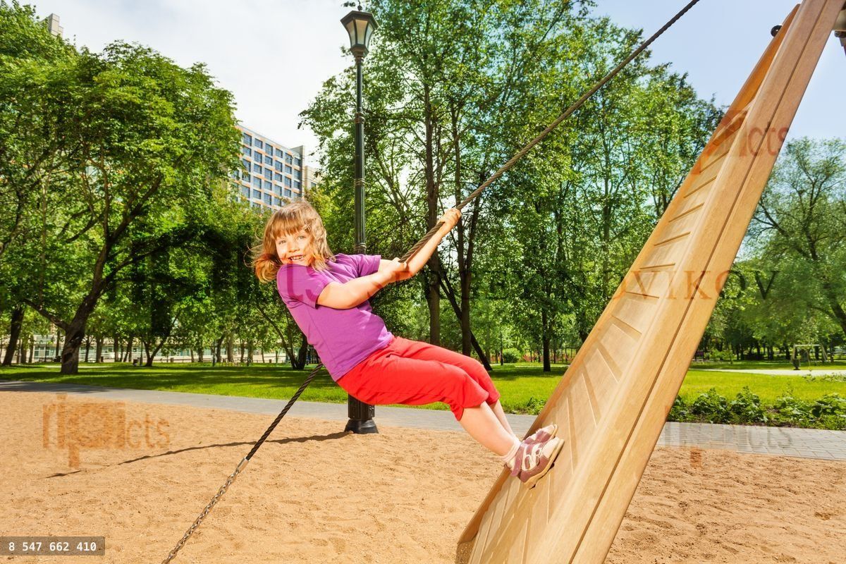 Girl climbing on wooden construction in the park