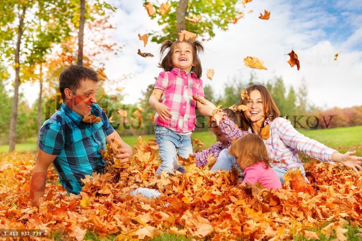 Maman et les filles lancent des feuilles en l'air