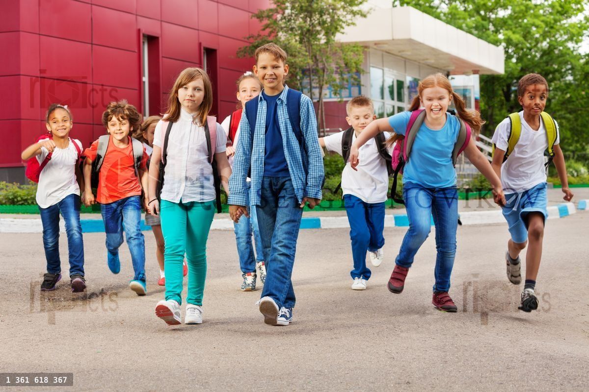 Children with rucksacks near school walking