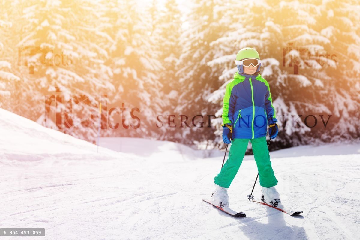 Young boy learning to ski in high mountains