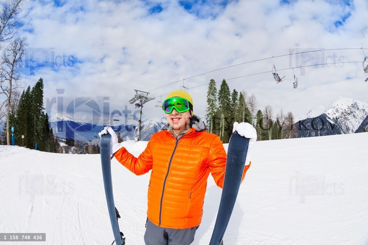 Young man in mask holds ski during mountain trip