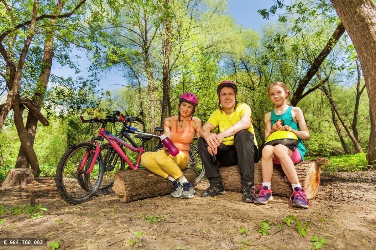 Active family resting on the logs after cycling