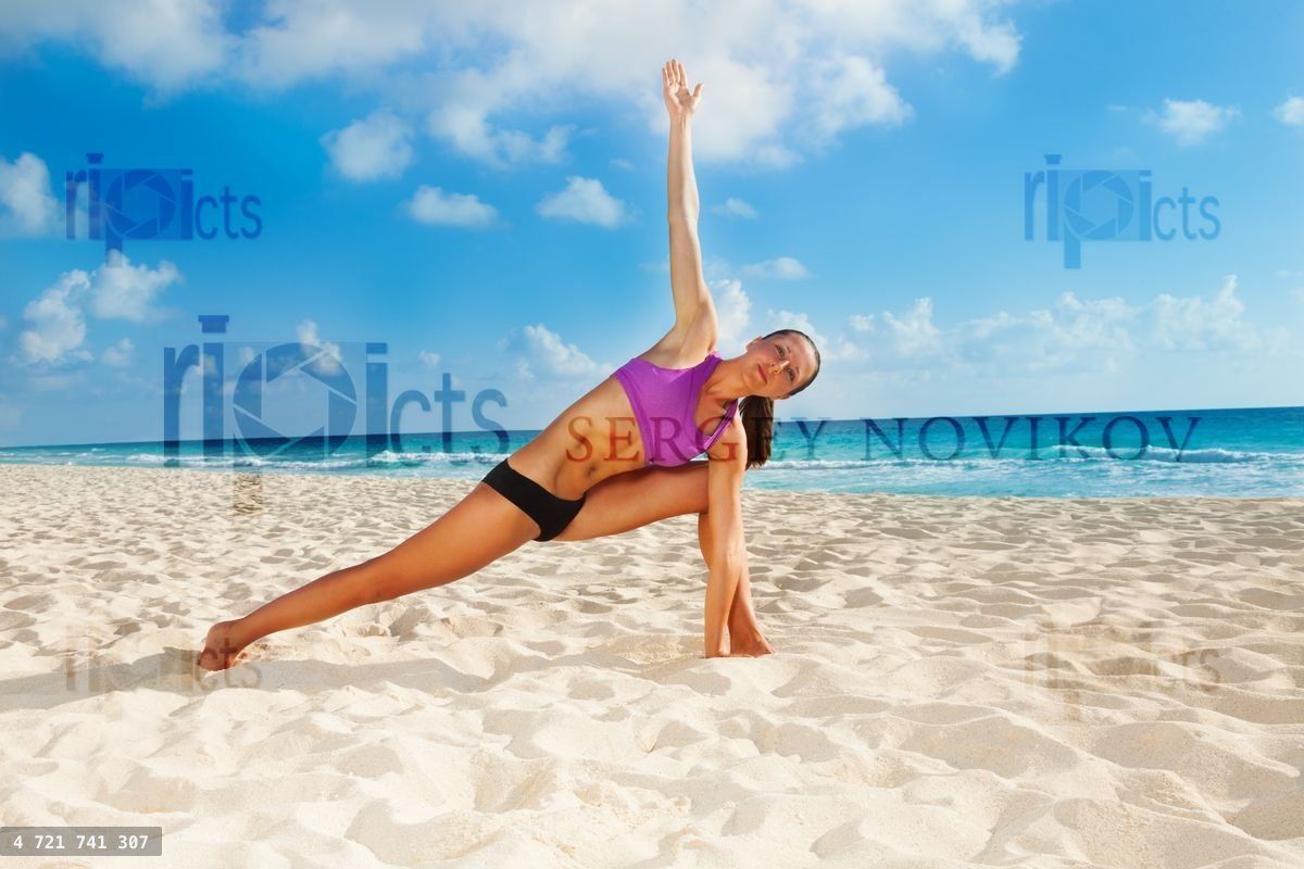 Woman on beach with arm up and legs apart