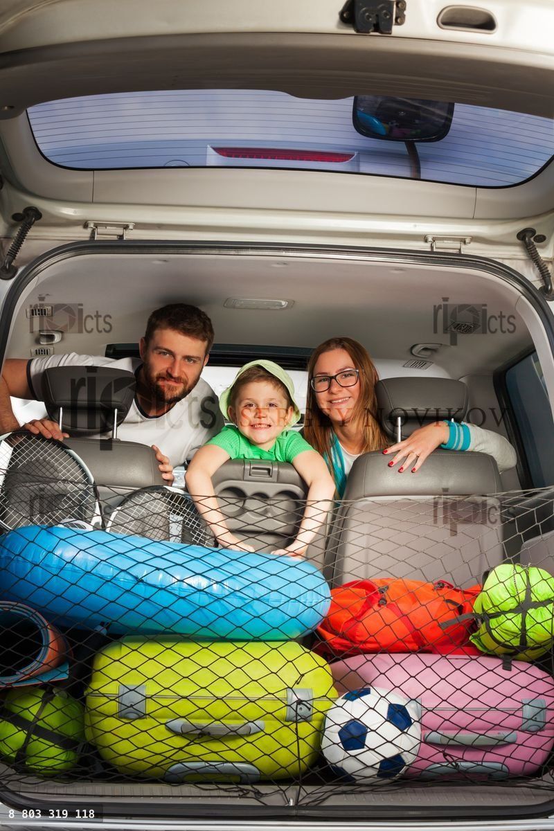 Famille heureuse assise dans un monospace plein de bagages