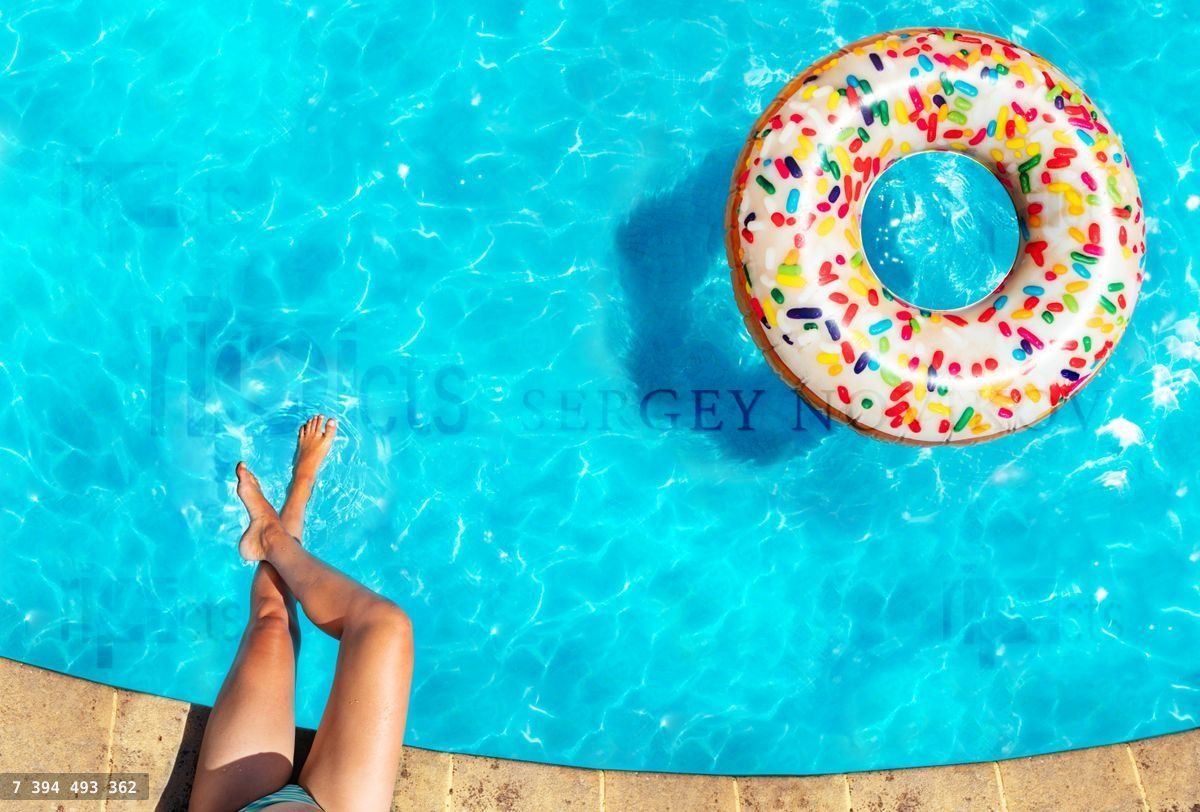 Woman's legs, inflatable doughnut swim in pool