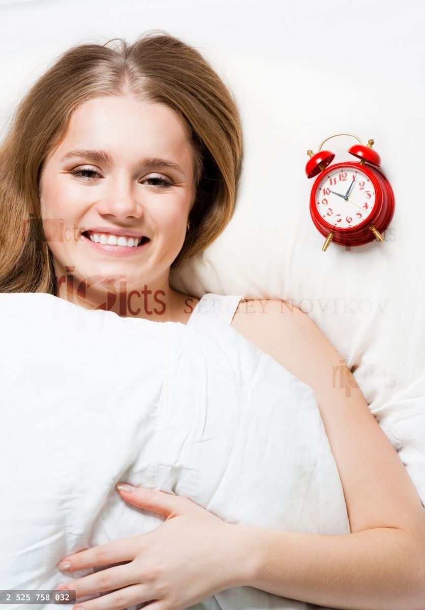 Woman lay on pillow with alarm