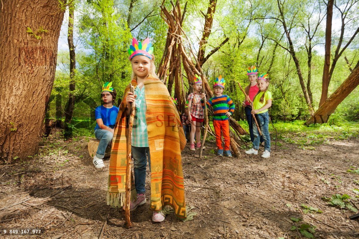 Young girl playing Red Indian chief in the forest